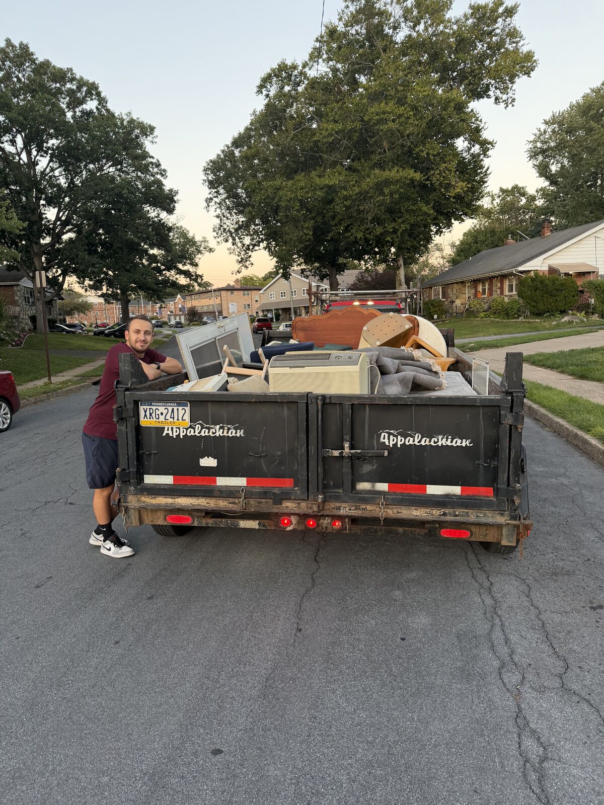 Crew member beside a trailer loaded with furniture and household items at a recent Dave's Hauling job
